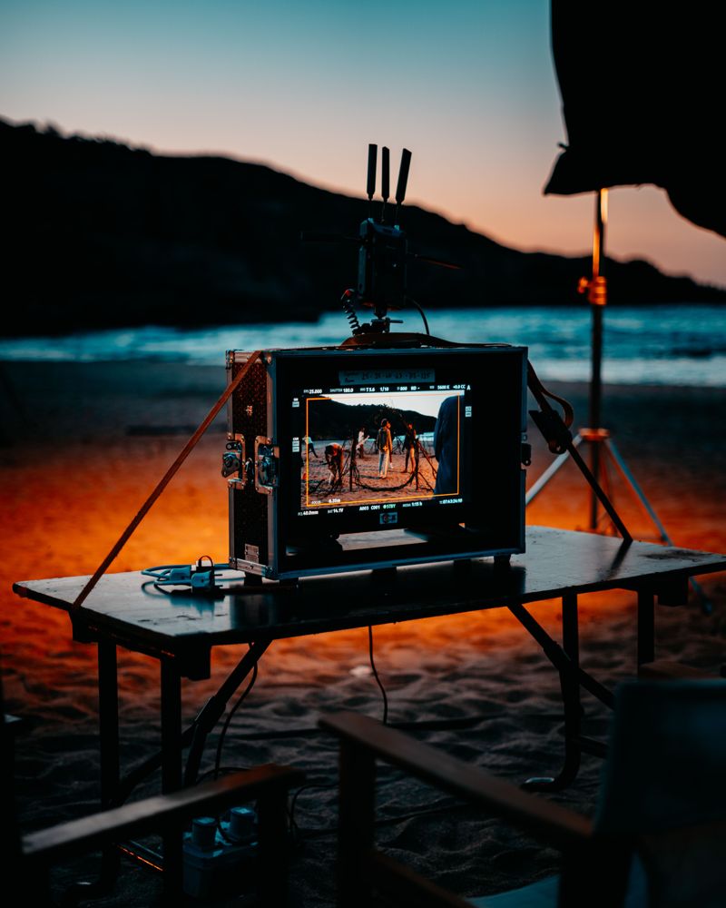 Monitor de rodaje en una playa al atardecer