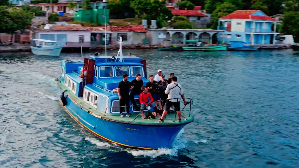 Barco azul con pasajeros en una bahía